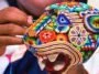 Artesana realizando arte huichol con una figura de un jaguar hecha de chaquira