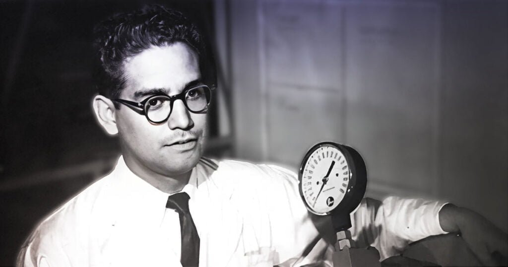 Fotografía de Luis Miramontes en blanco y negro frente a equipo de laboratorio